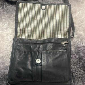 A fossil black leather woman’s cross body should bag purse.